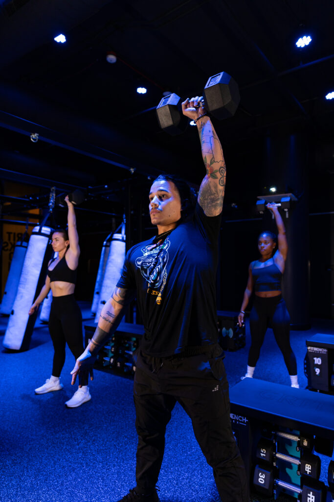 Charlotte Gritbox coaches demonstrating a dumbbell snatch.